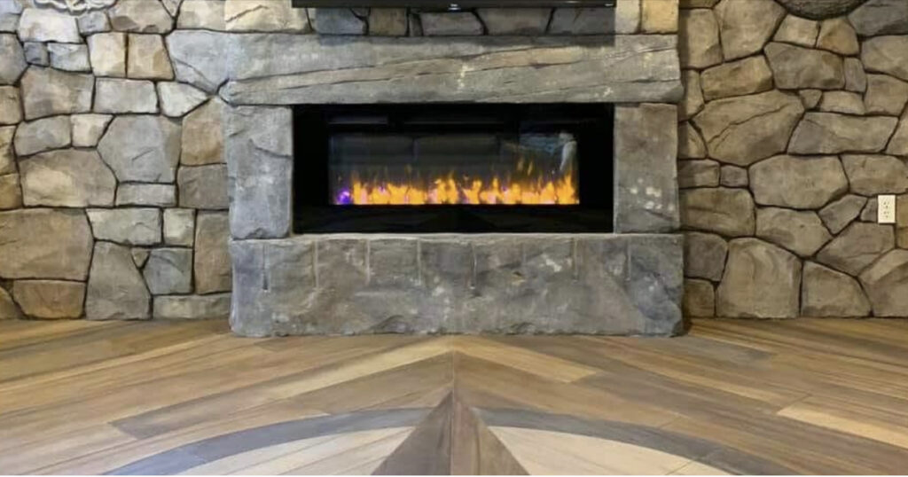Custom electric carved concrete fireplace with hearth, mantle, and decorative concrete floor in Florida